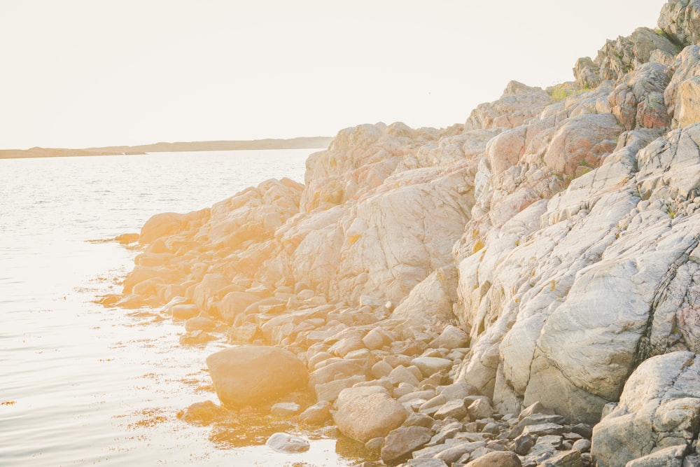 brown rocky mountain by the sea during daytime