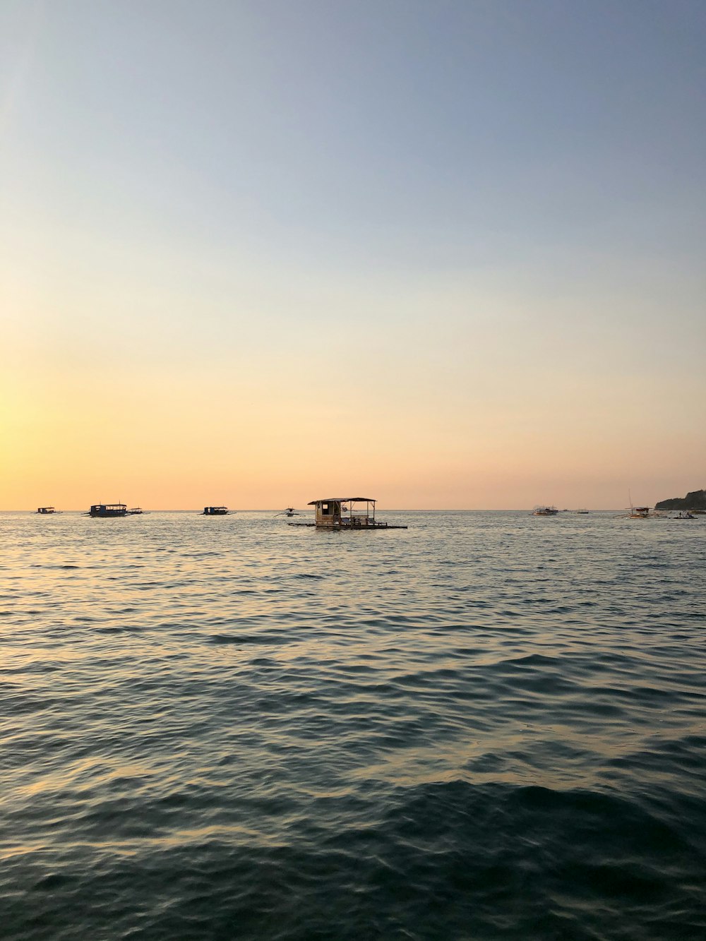 casa di legno marrone sul mare durante il tramonto