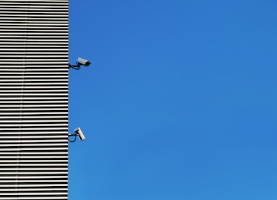 Two high-definition security cameras installed on a contemporary building facade.