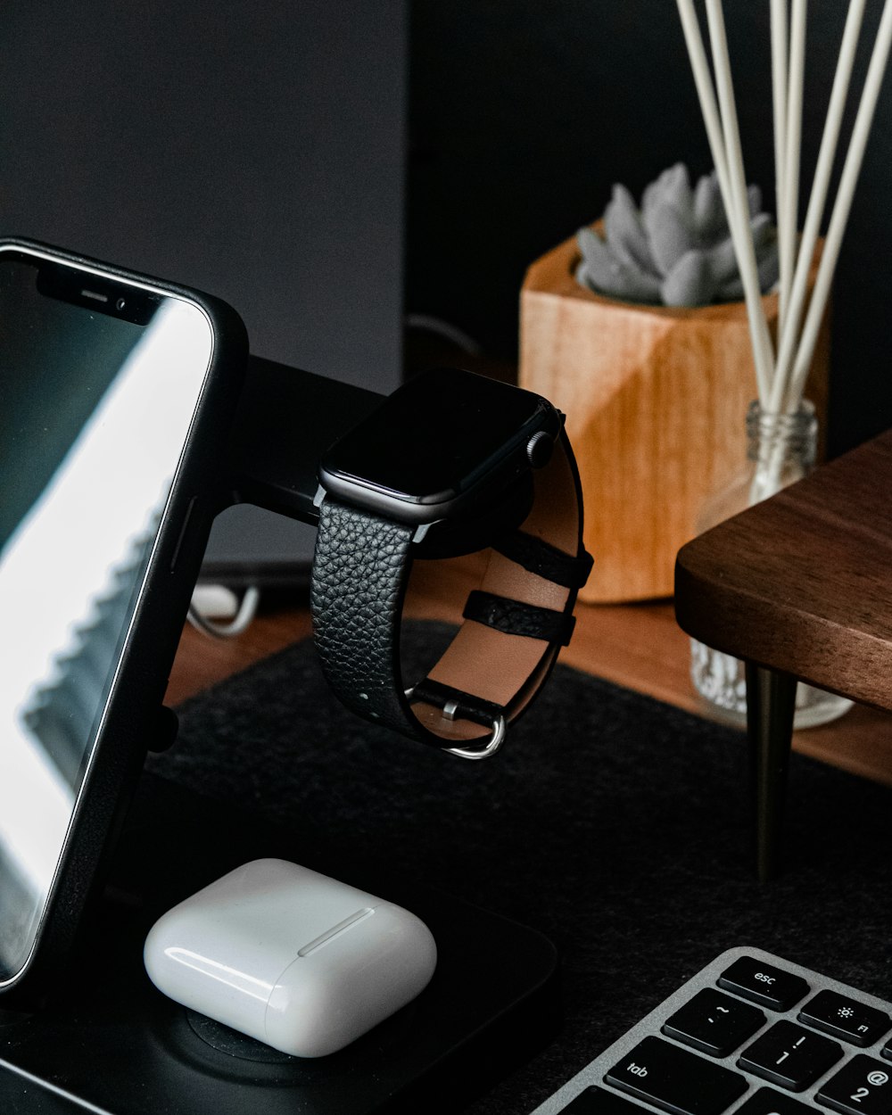 black and silver watch on black wooden table