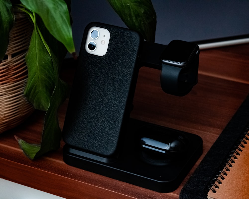 funda negra para iPhone sobre mesa de madera marrón