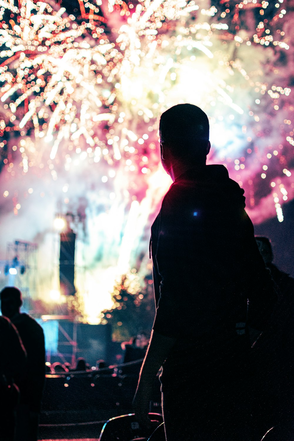 silhouette of man standing in front of fireworks display