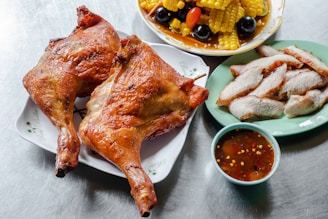 A vibrant spread of assorted dishes including grilled chicken, pasta, sliders, salad, fruit platter, and chocolate mousse on a rustic wooden table.