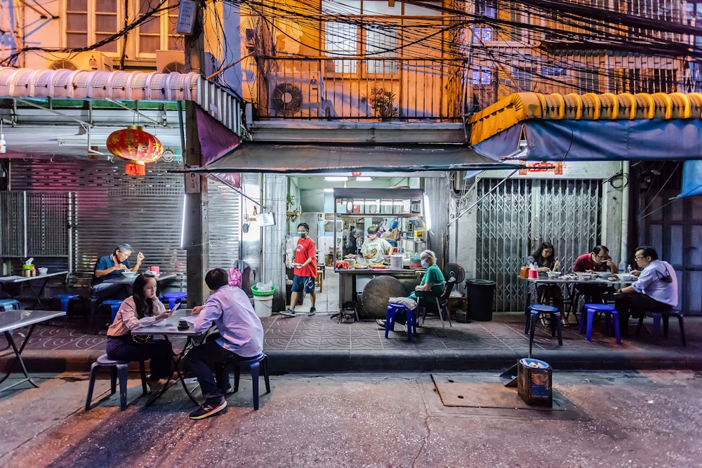 people sitting on chair near food stall during daytime