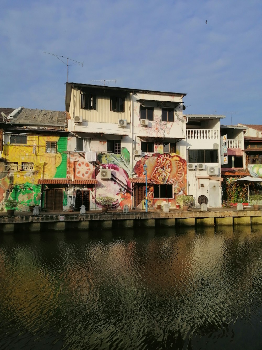 edifício de concreto branco e marrom ao lado do rio durante o dia