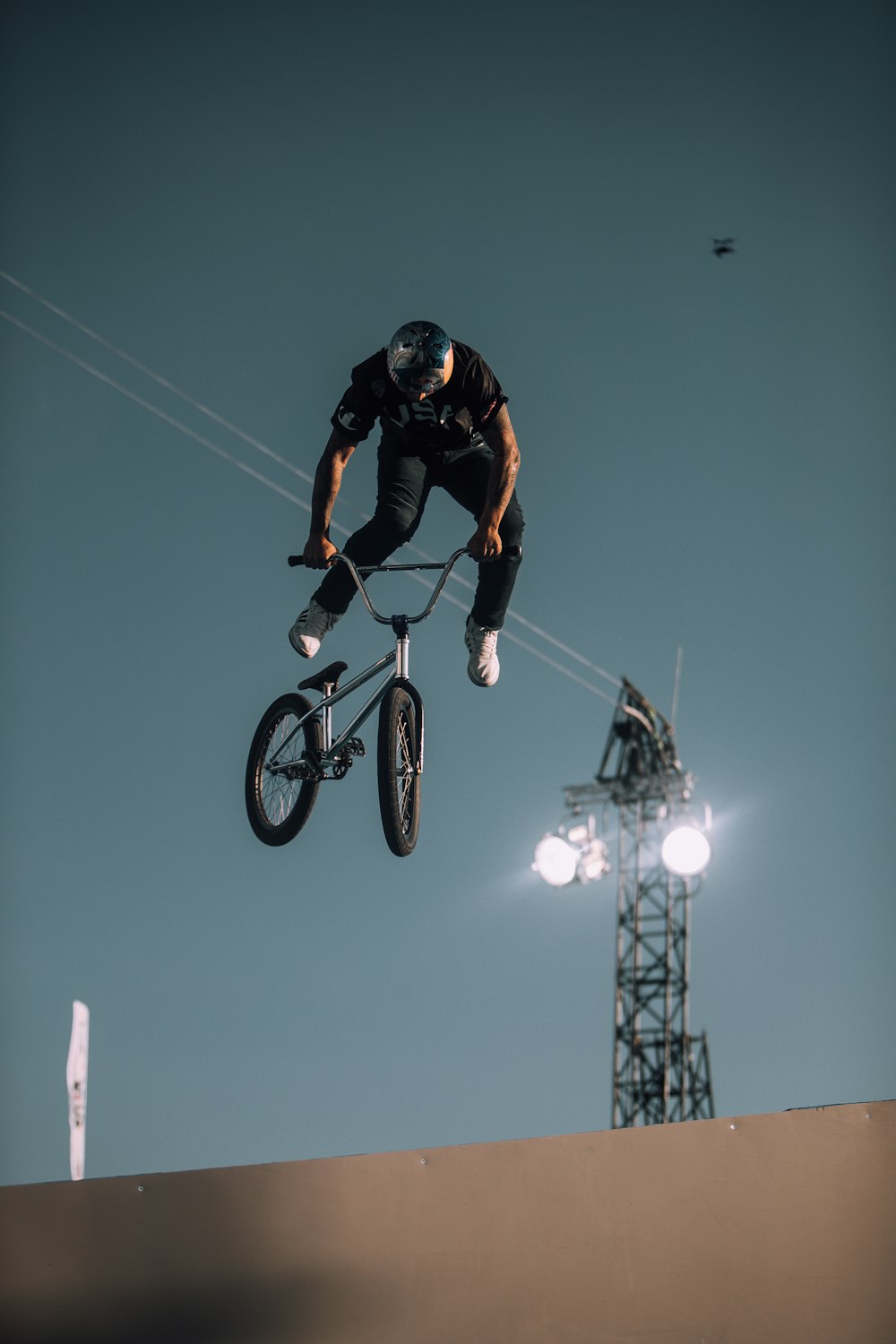 man in black and orange jacket riding on black mountain bike