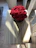 Close-up of a vibrant forever rose arrangement in a rustic vase on a wooden table.