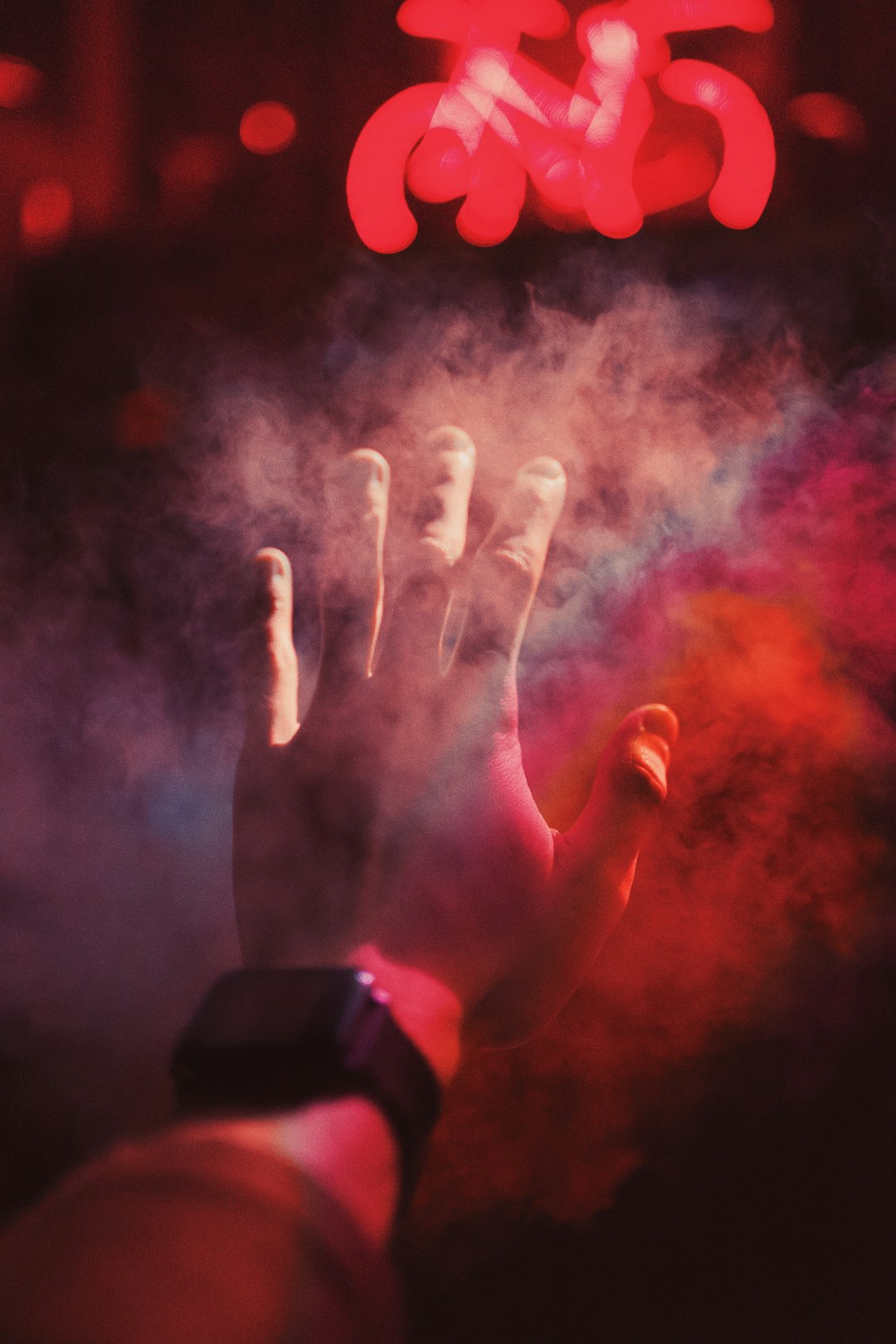 person raising his hands with red and white powder