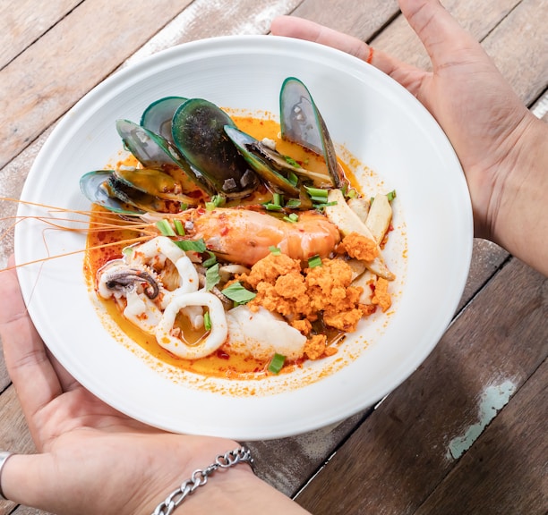 person holding white ceramic plate with food