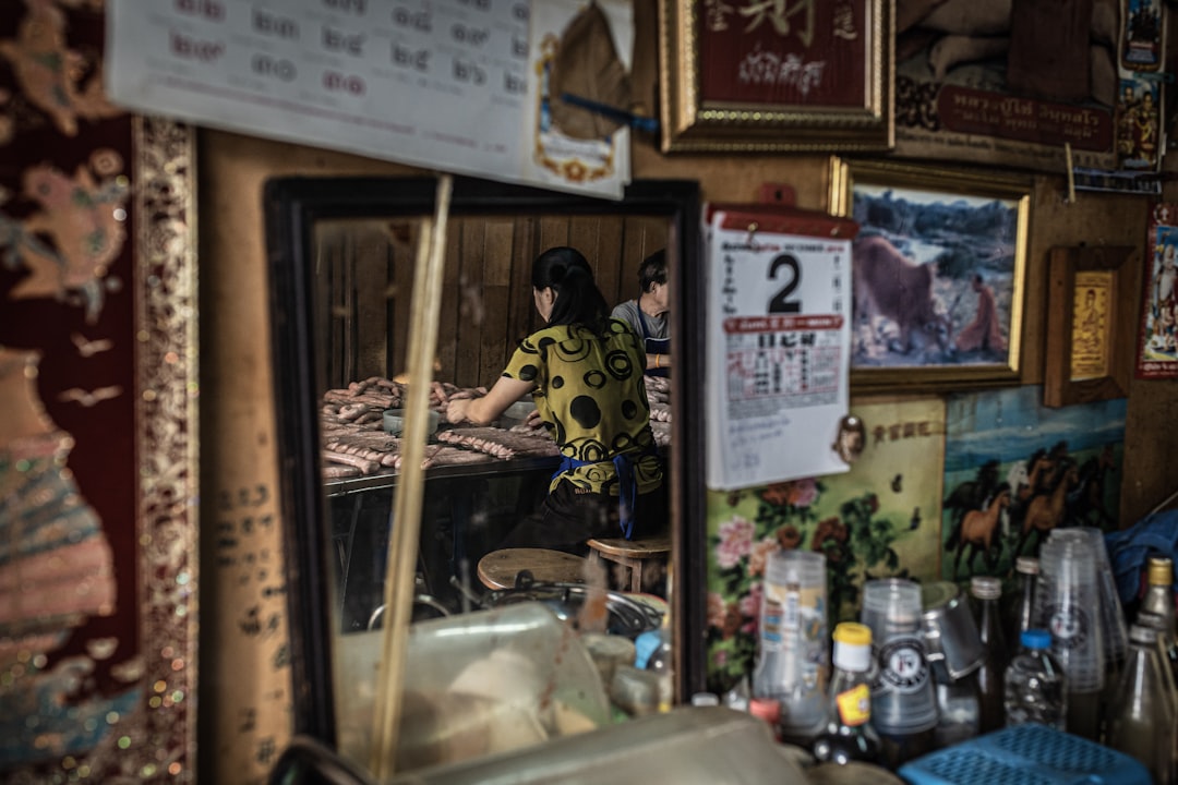 woman in black and yellow mickey mouse shirt standing beside brown wooden frame, Shophouse food factory and eatery in Ba
