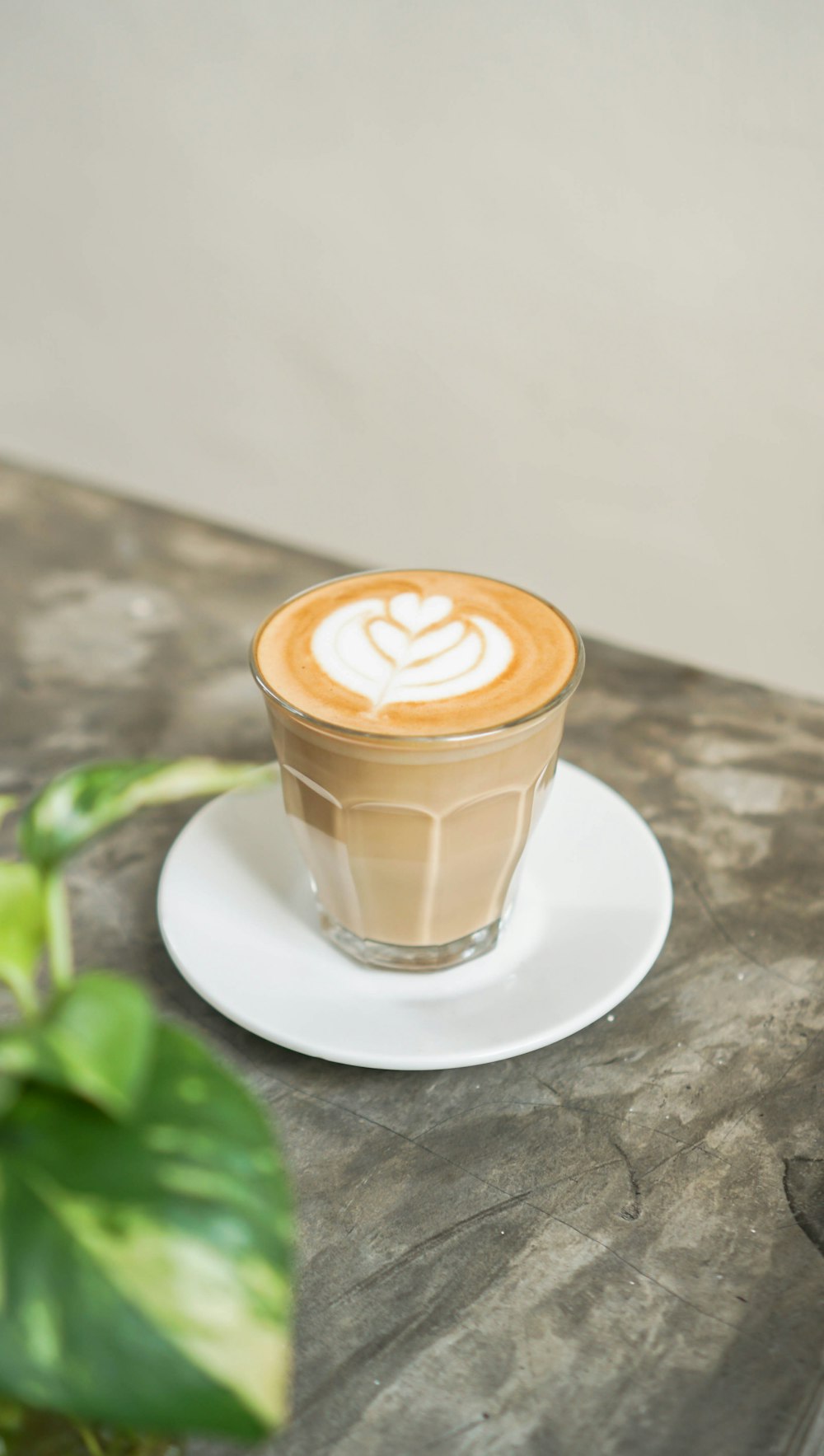 white ceramic cup with cappuccino on white ceramic saucer