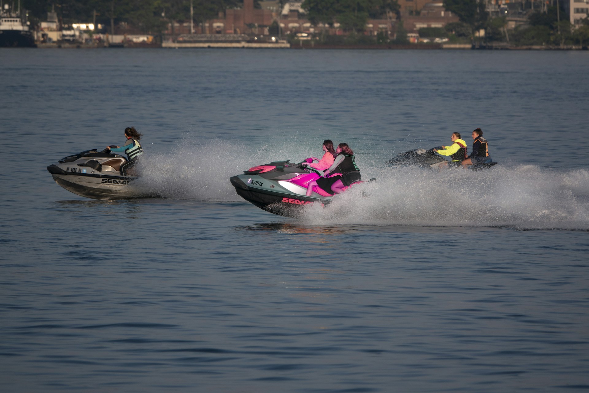 2 people riding on red and white personal watercraft