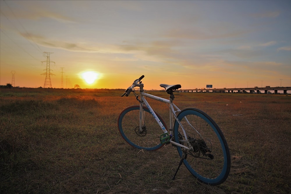 black and white road bike on green grass field during sunset