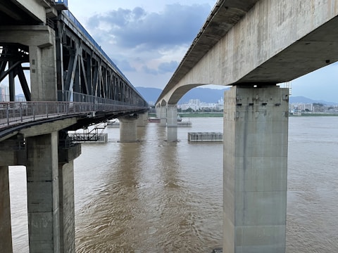 Bridge infrastructure project over a river surrounded by mountains.