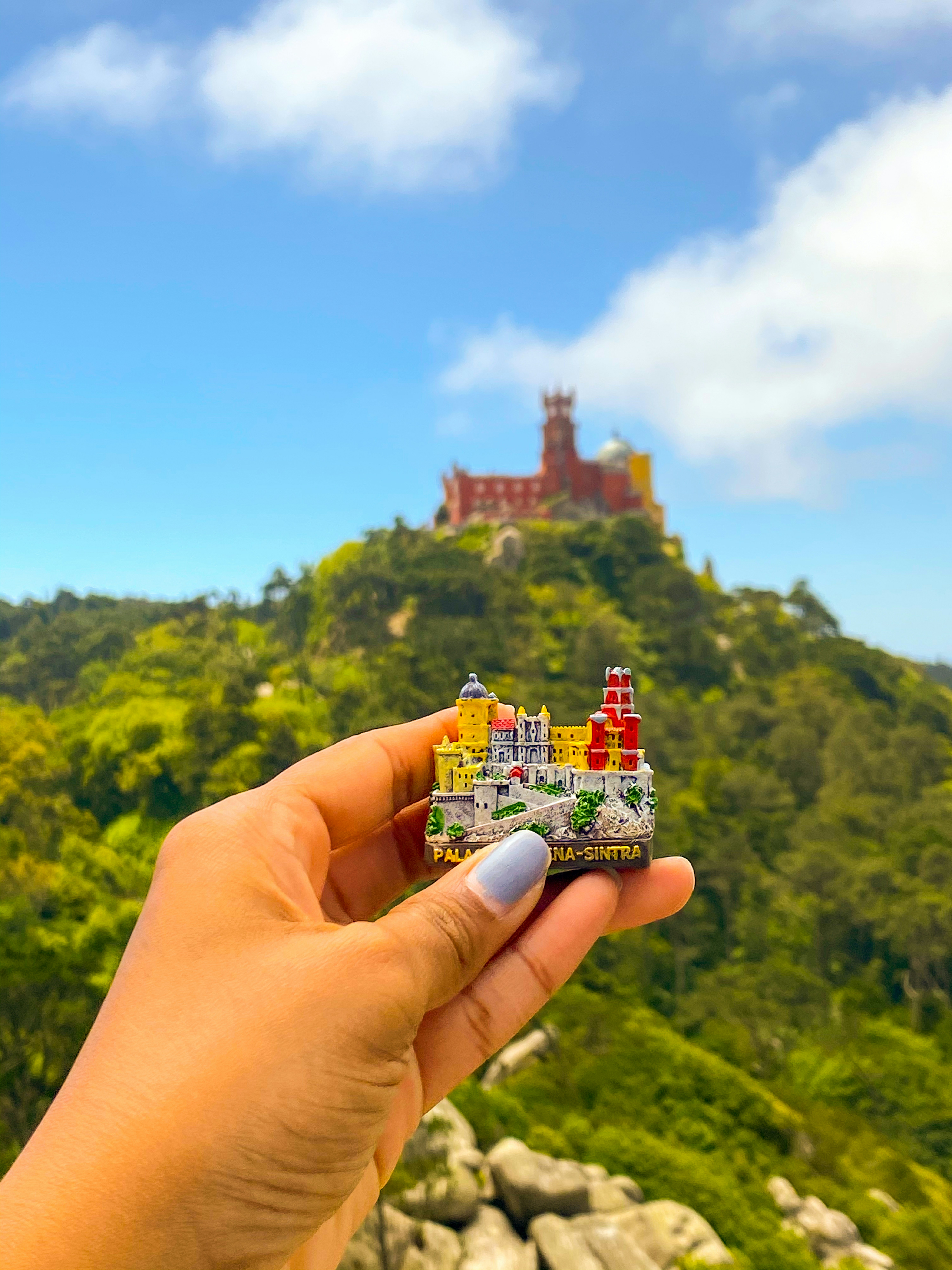 person holding red and white house miniature