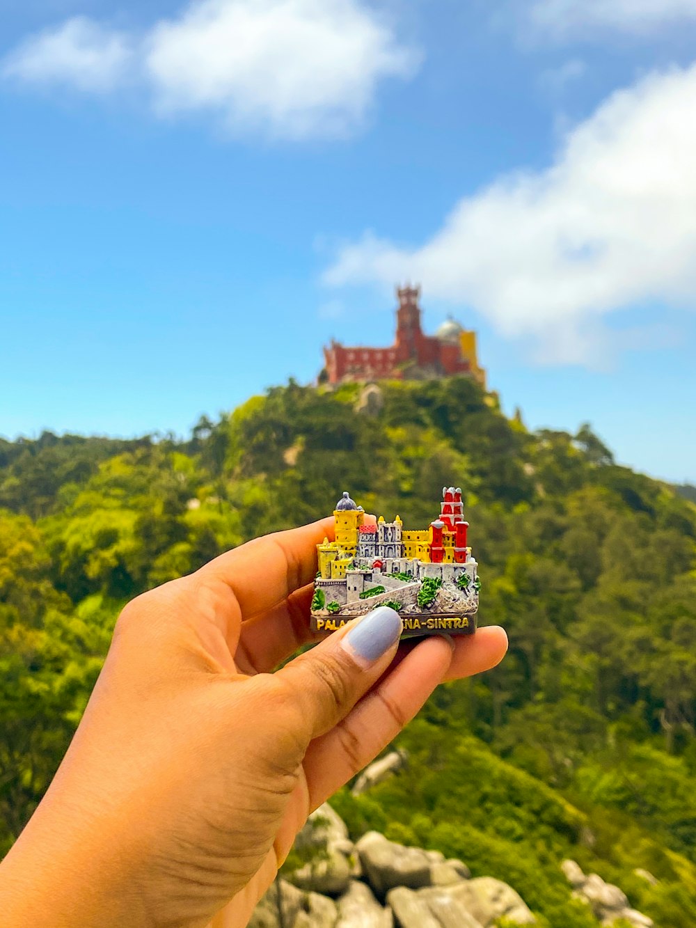 Person mit roter und weißer Hausminiatur