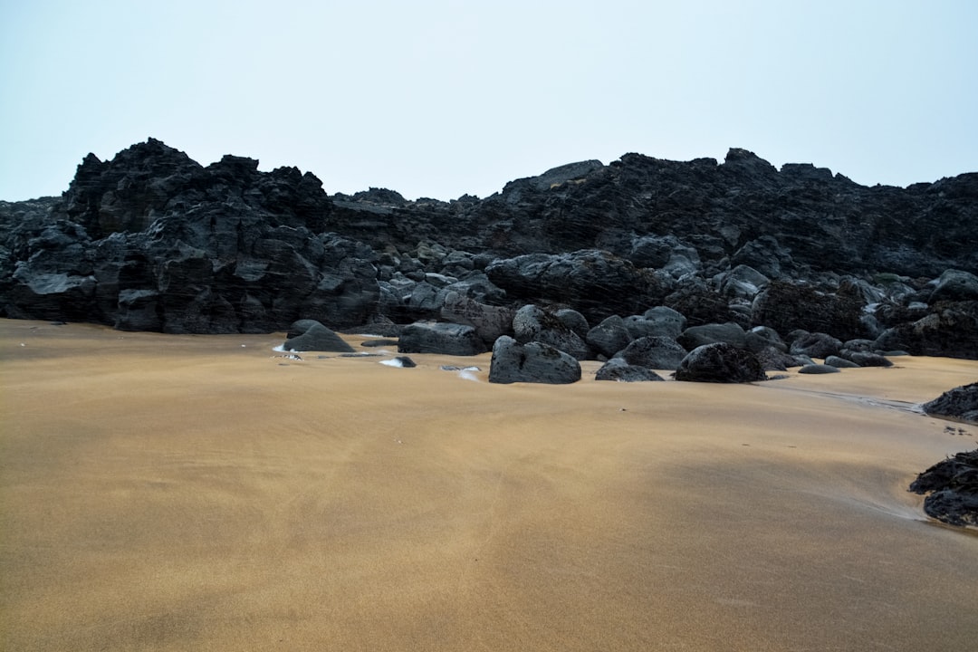 black rocks on brown sand