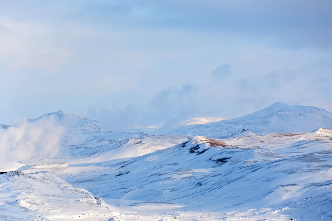 snow covered mountain under white clouds during daytime