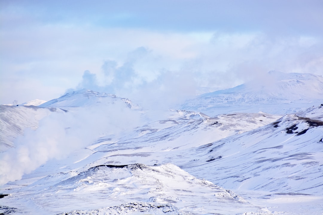 snow covered mountain under white clouds during daytime