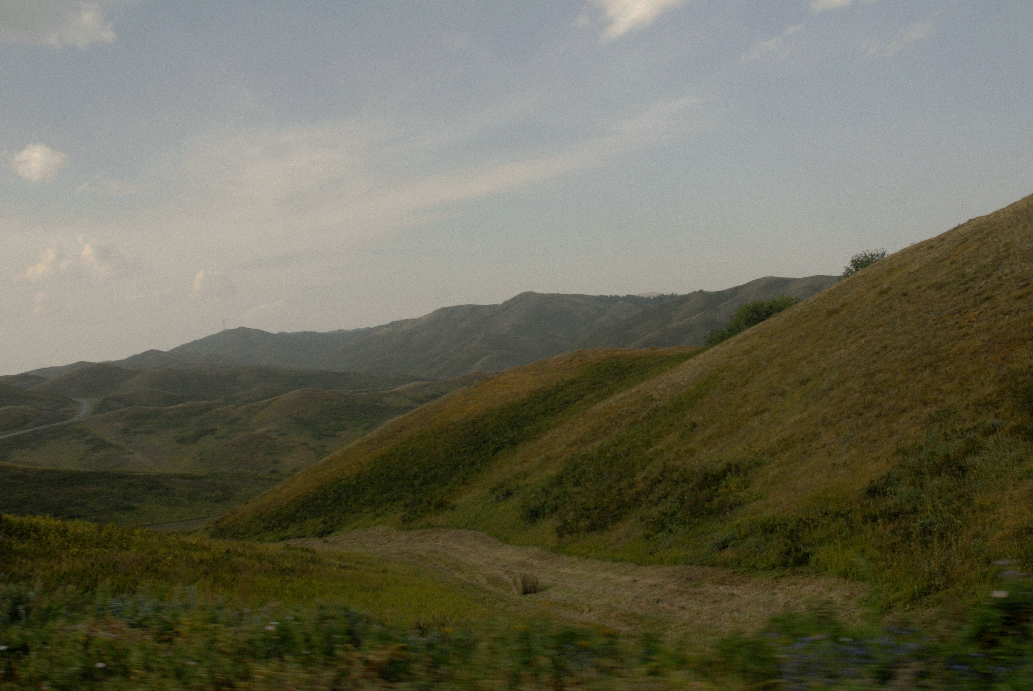 green and brown mountains under white clouds and blue sky during daytime