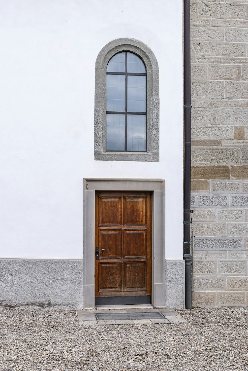 Porta di legno marrone su edificio in cemento bianco