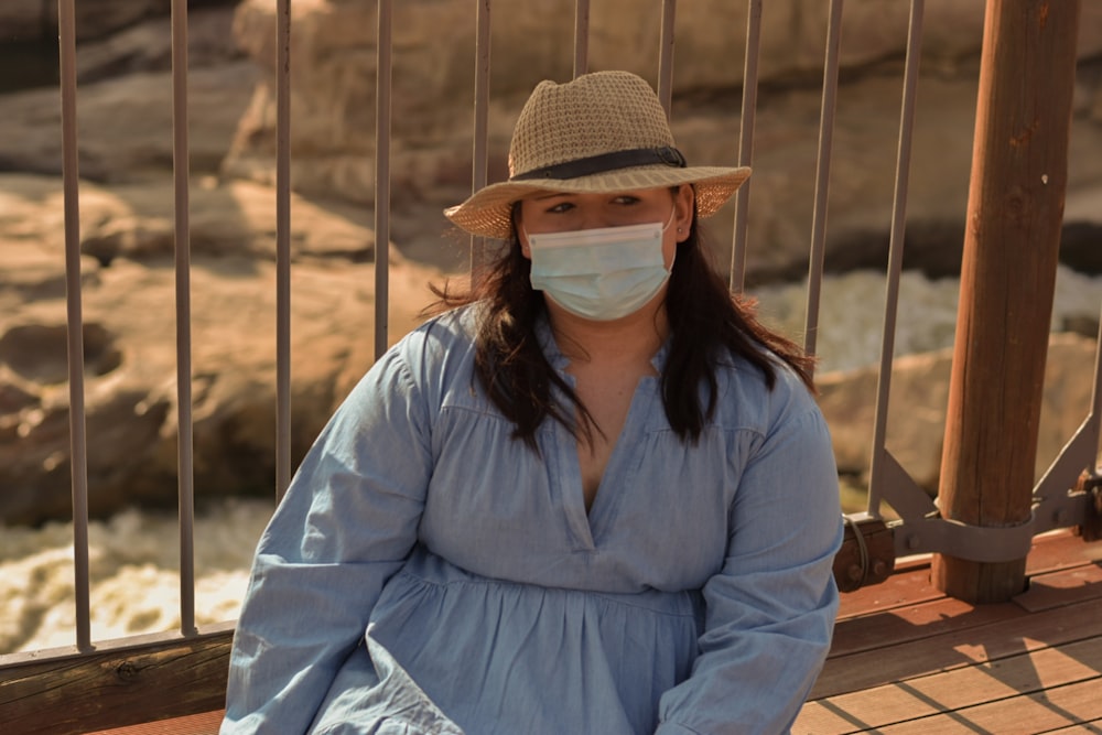 woman in blue dress shirt wearing brown hat and sunglasses