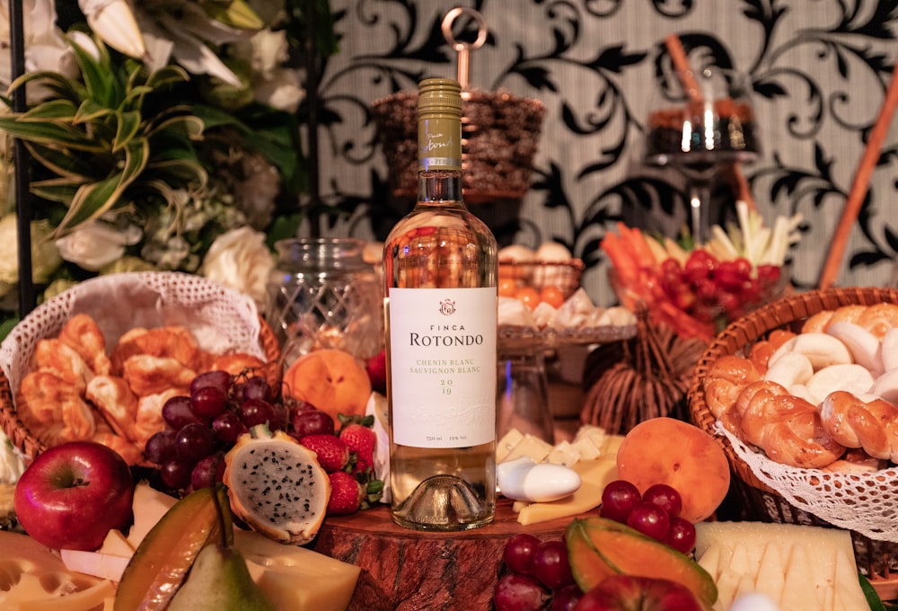 clear glass bottle surrounded by fruits