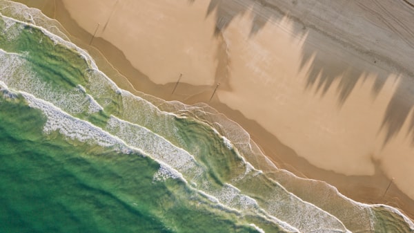 Bird's eye aerial view of beach and ocean coastline for hotel distance check