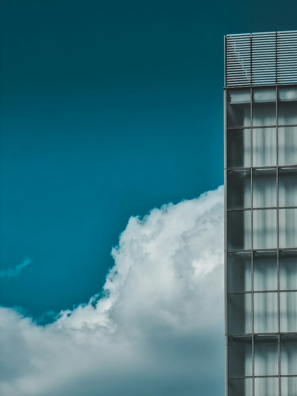 white clouds over glass building