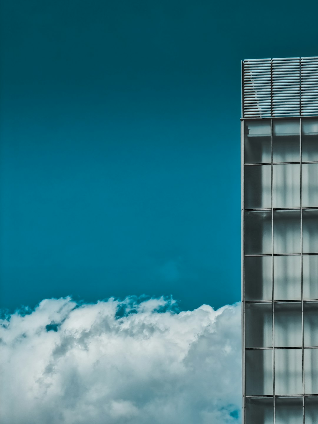 white clouds over glass building