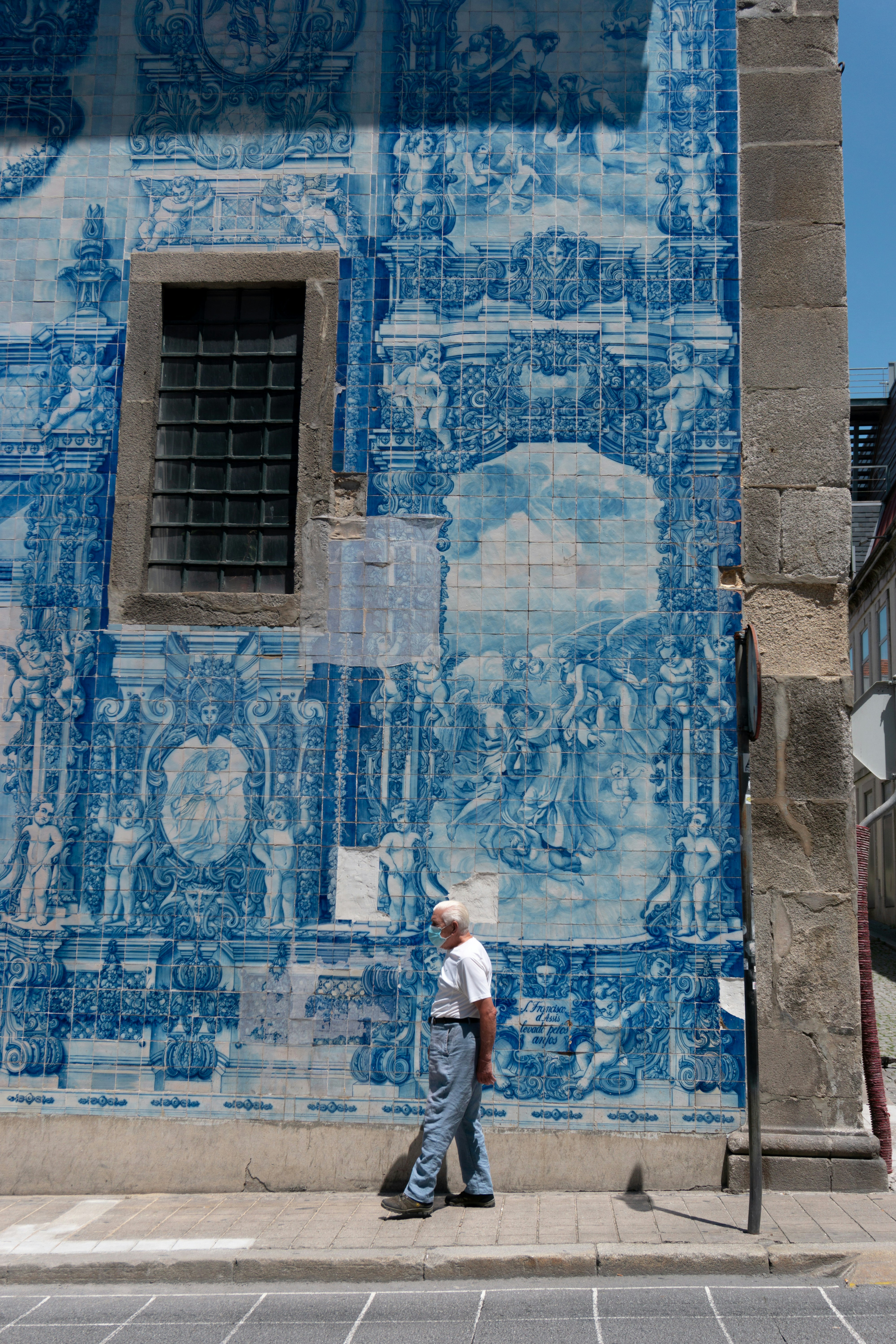 woman in white shirt standing in front of blue and white concrete building
