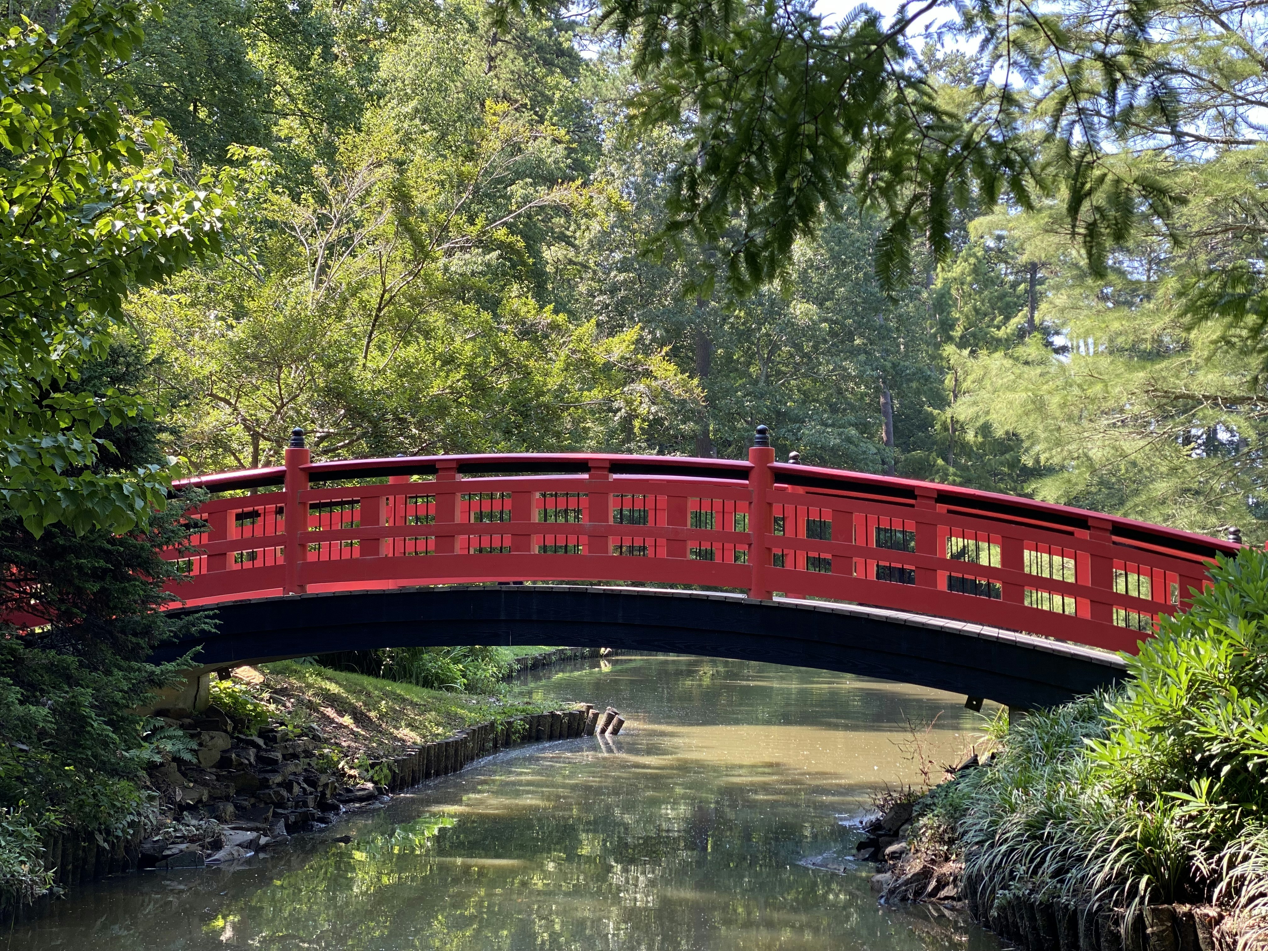 Red bridge over still water