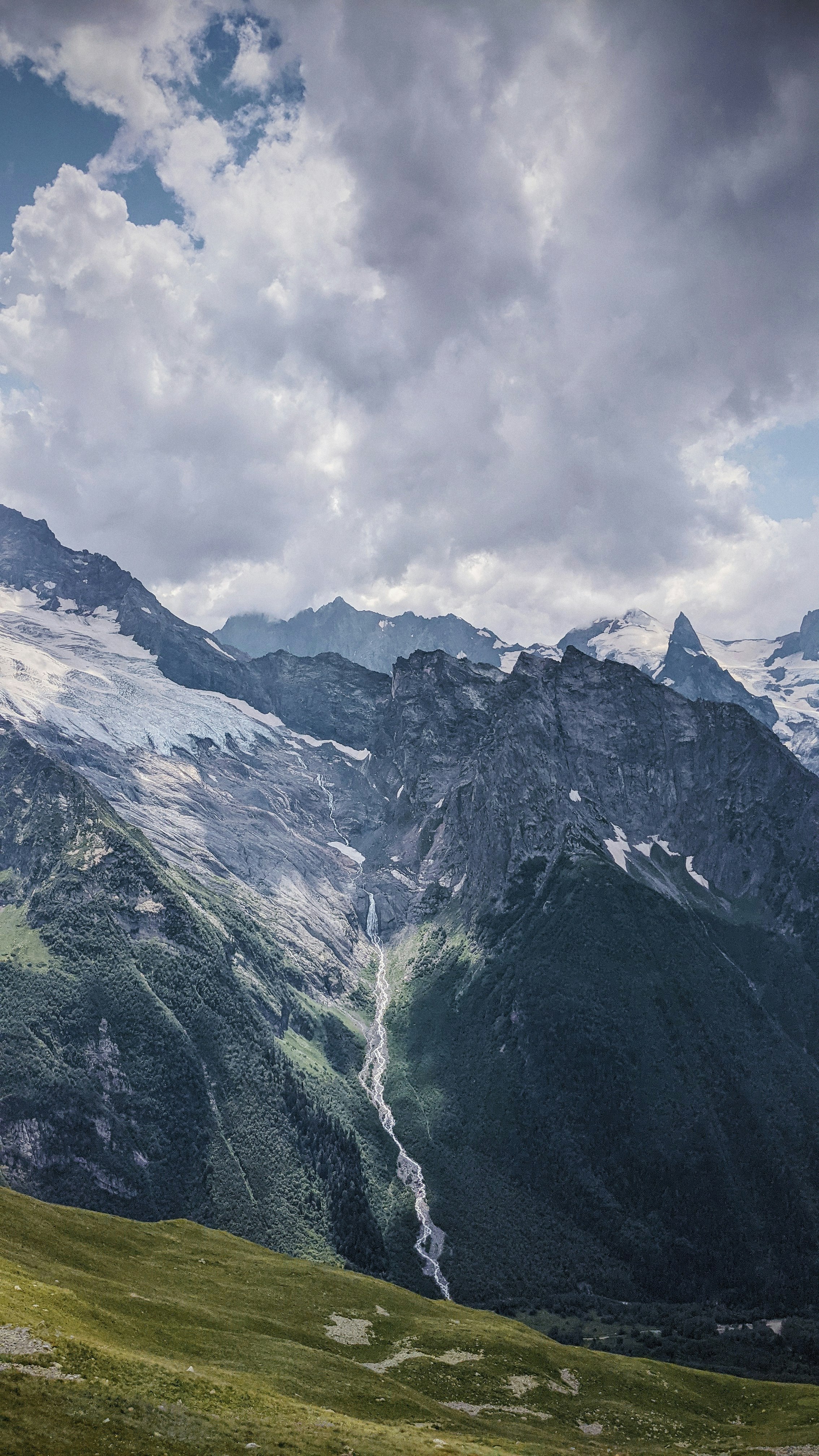 green and white mountains under white clouds during daytime