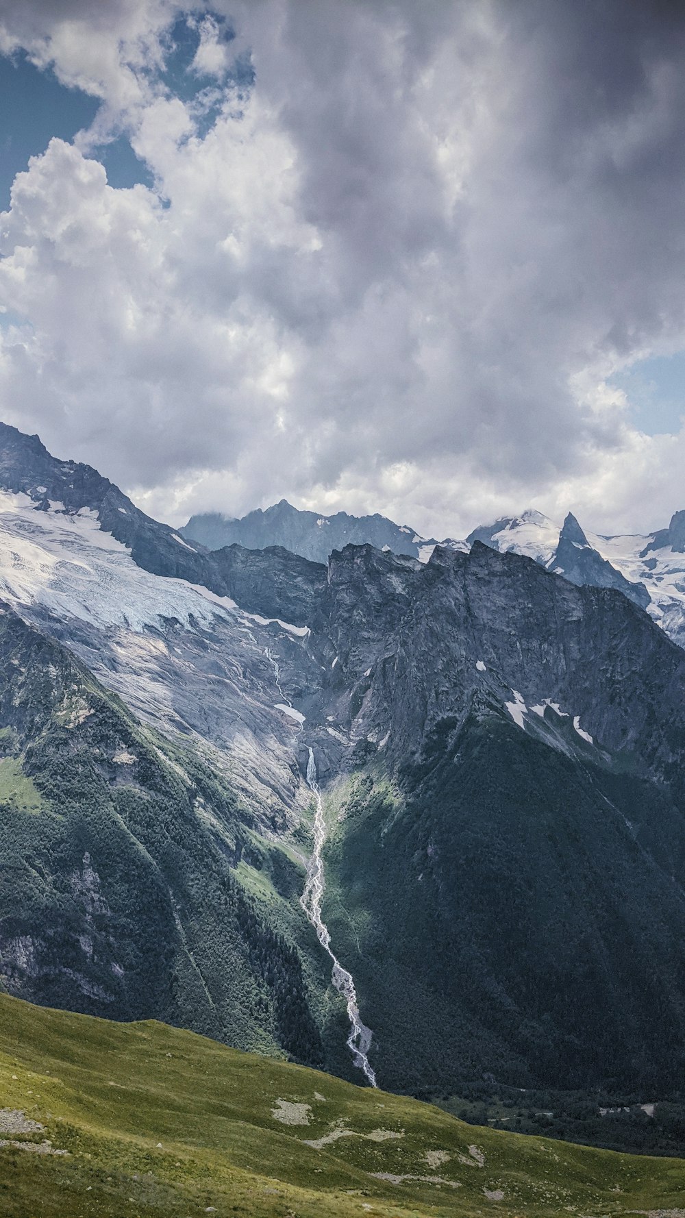 green and white mountains under white clouds during daytime