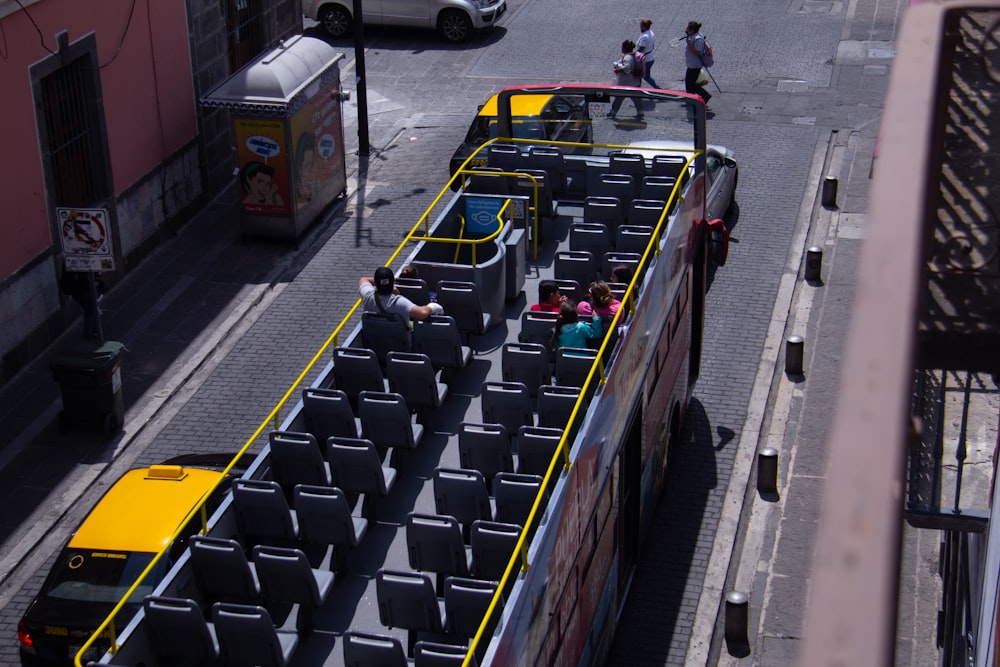 people riding on blue and yellow cars on road during daytime