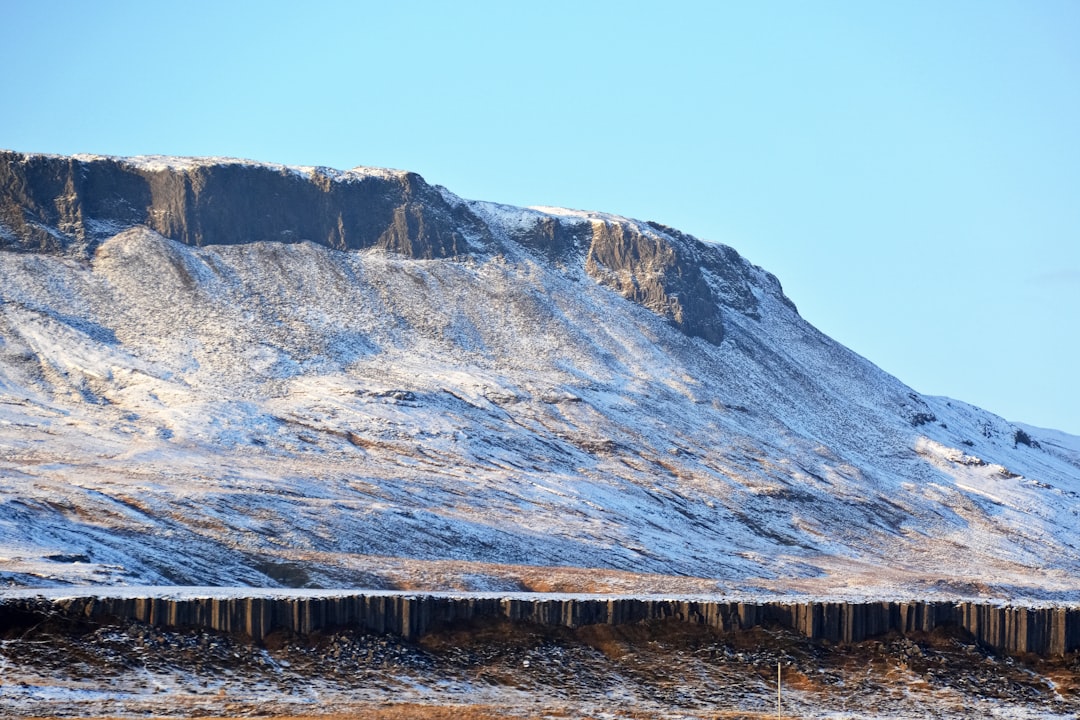 brown wooden dock near brown rocky mountain during daytime