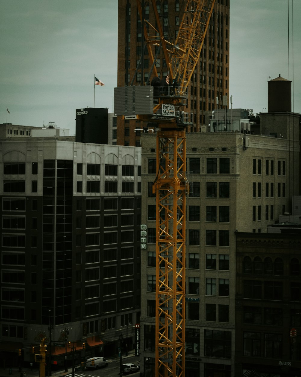 grue jaune près d’un bâtiment en béton blanc pendant la journée