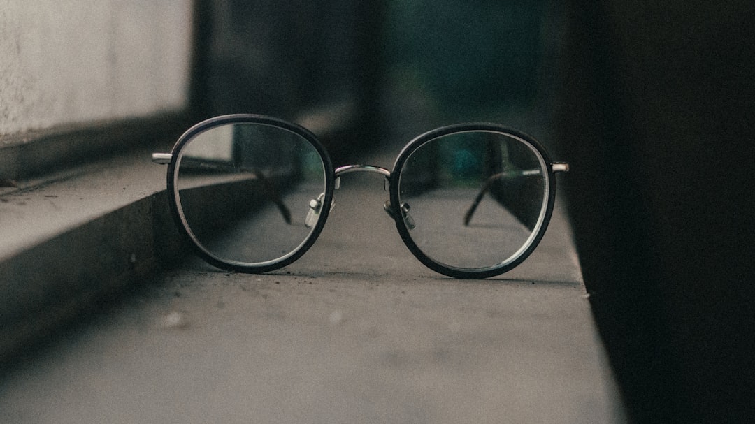 black framed eyeglasses on gray surface