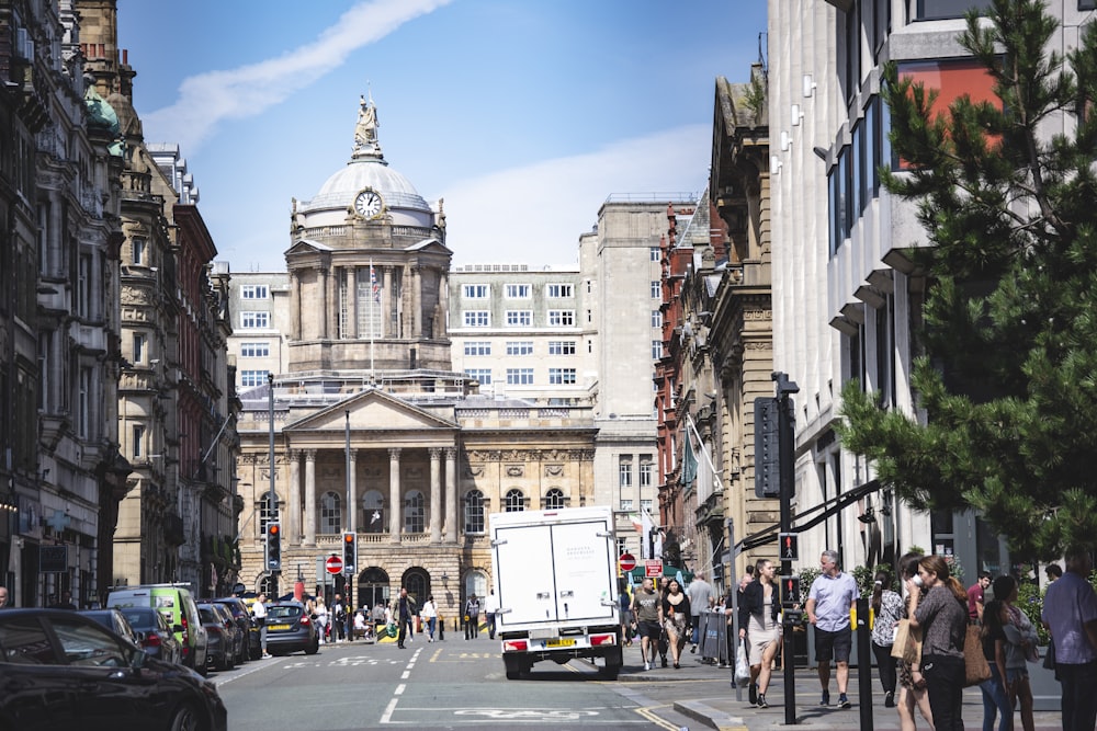 cars parked on street near white concrete building during daytime (demonstrates colonialism) 