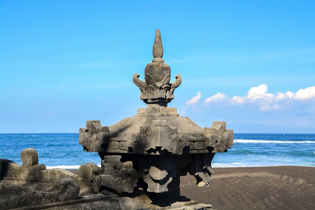 black concrete statue on beach during daytime