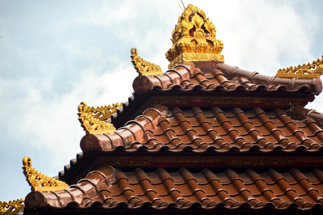 gold buddha statue under white clouds during daytime