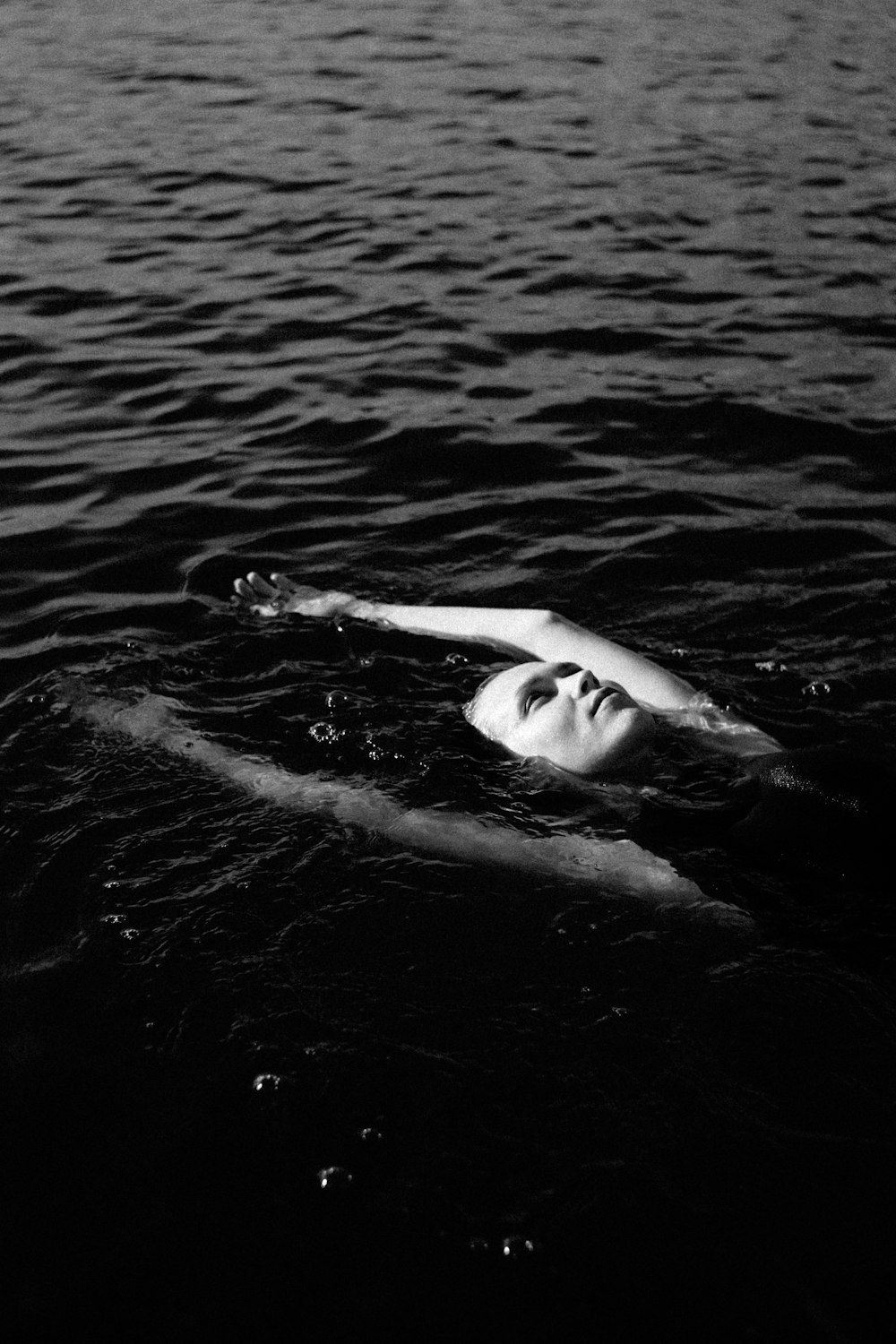 grayscale photo of woman surfing on water