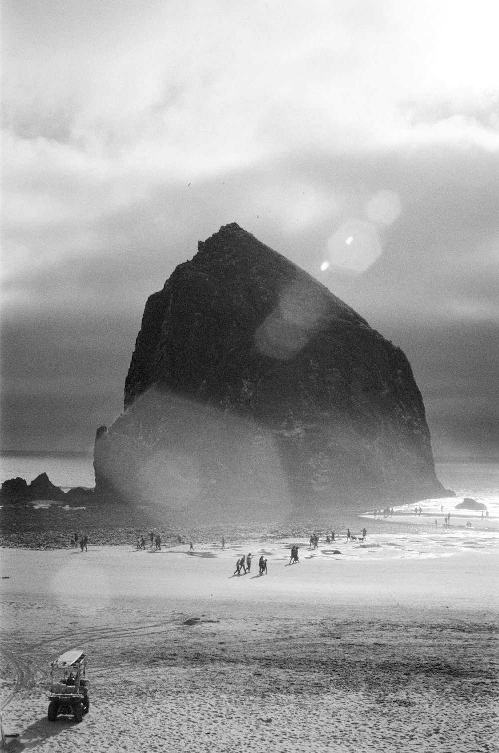 people walking on beach near rock formation during daytime