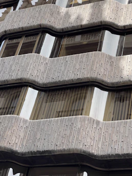 Close-up of a sleek glass windscreen protecting a balcony on a windy day.