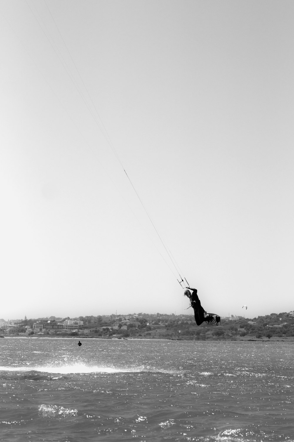 grayscale photo of person fishing on sea