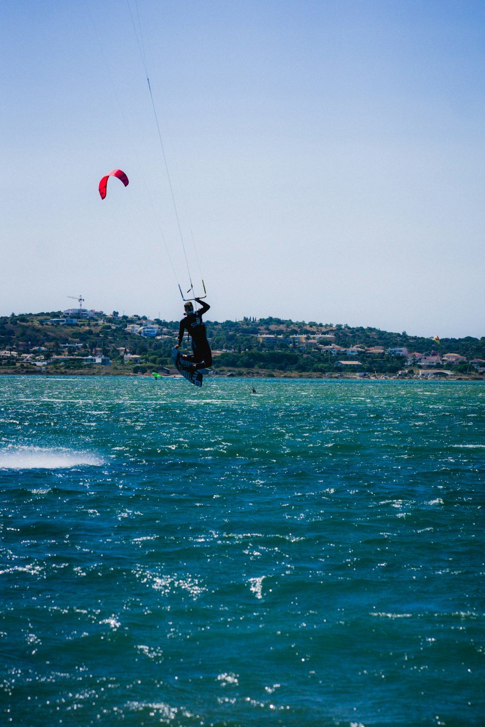 person in black wetsuit surfing on sea during daytime