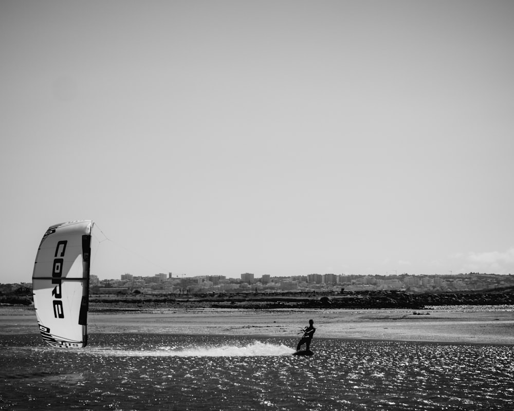 grayscale photo of man surfing on sea