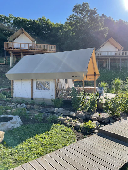 A cozy family enjoying a peaceful moment together inside a glamping tent surrounded by lush greenery.