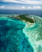 An aerial view of a tropical island surrounded by turquoise sea.