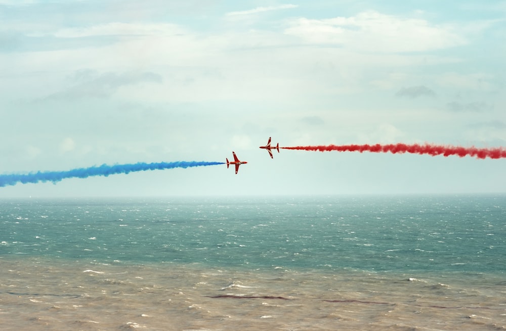 red and white plane flying over the sea during daytime